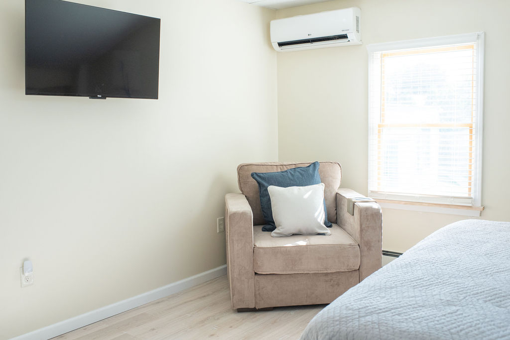 Primary bedroom TV and chair